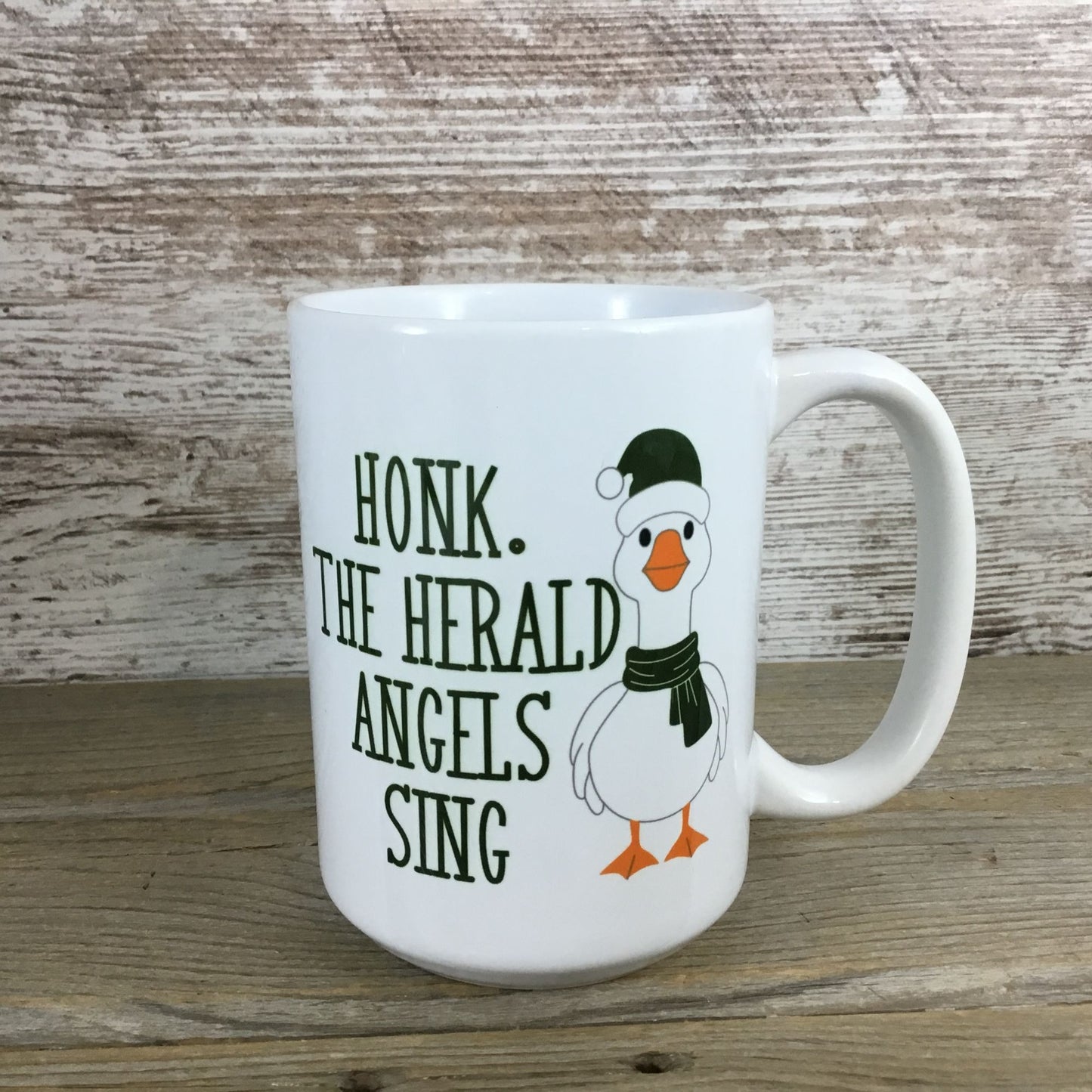 White mug with a Christmas-themed design featuring a goose wearing a hat and scarf
