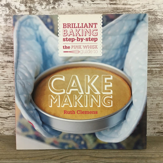 Book cover of 'Brilliant Baking Step-by-Step' by Ruth Clemens on a wooden surface