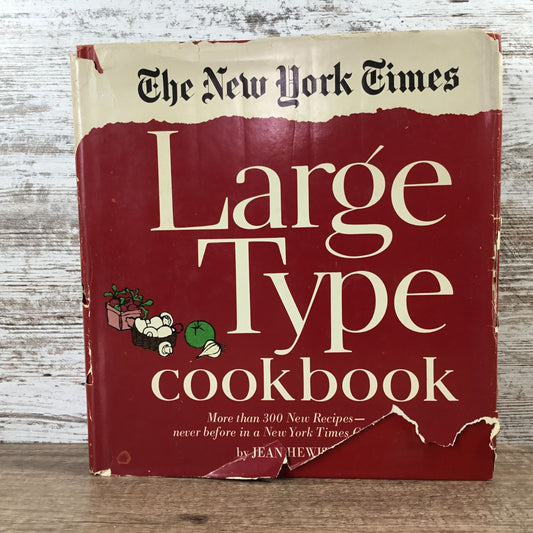 The New York Times Large Type cookbook on a wooden surface with a rustic background