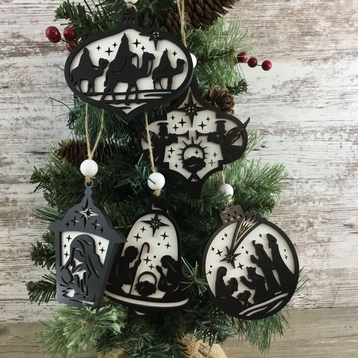 Decorative Christmas ornaments with black and white designs on a Christmas tree.