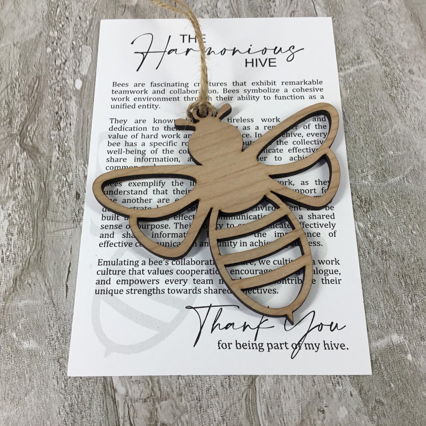 Wooden bee-shaped pendant on a card with text about teamwork and collaboration.