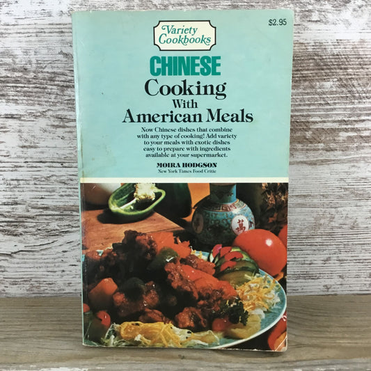 Cookbook cover of 'Chinese Cooking with American Meals' on a wooden surface