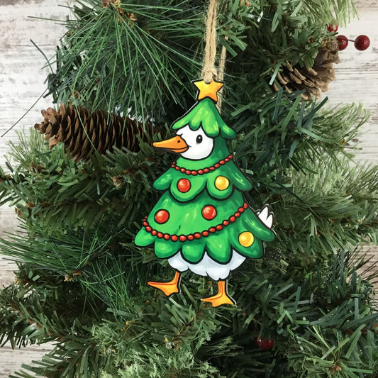 Christmas tree gooes ornament hanging on a Christmas tree with pine cones and berries.