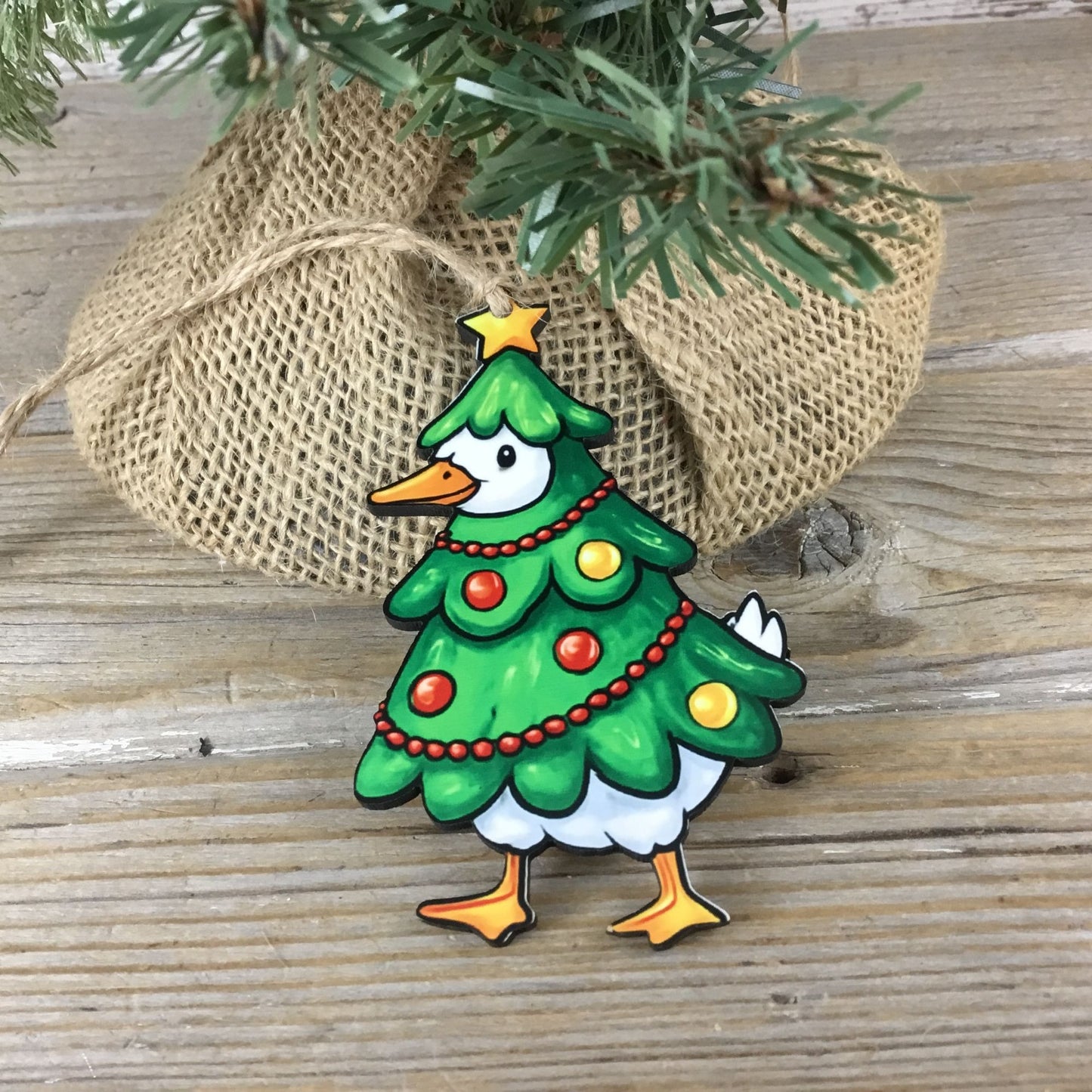 Decorative Christmas ornament shaped like a tree with a goose body on a wooden surface.
