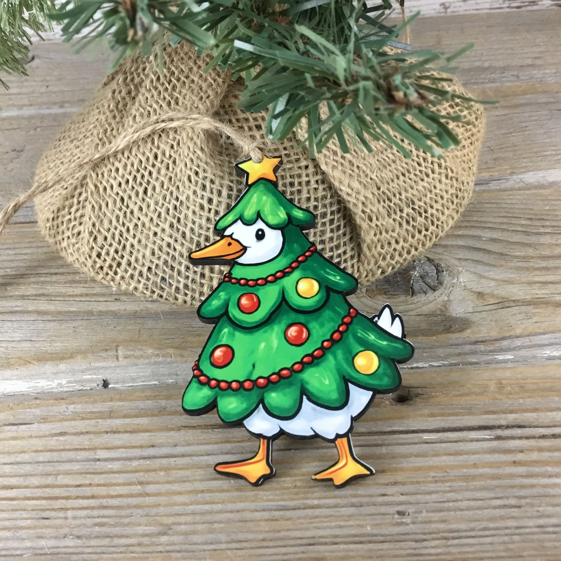 Decorative Christmas ornament shaped like a tree with a goose body on a wooden surface.