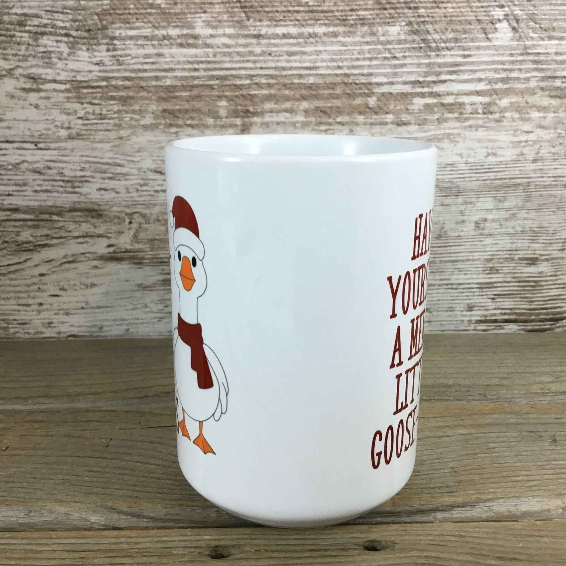 White mug with a cartoon goose and text on a wooden background