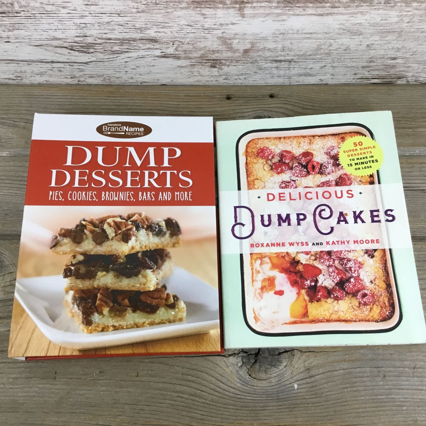 Two cookbooks on a wooden surface, one titled 'Dump Desserts' and the other 'Delicious Dump Cakes'.