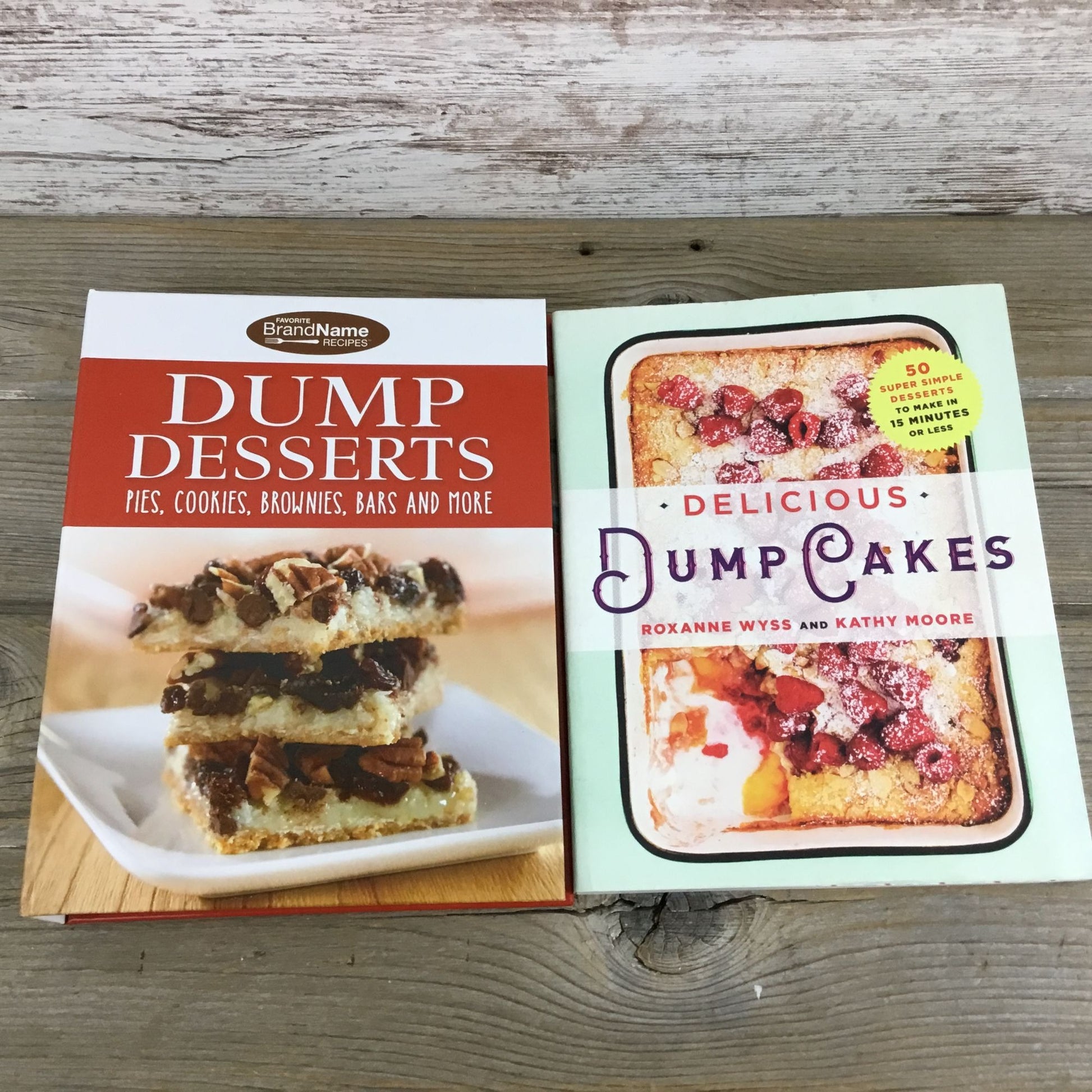 Two cookbooks on a wooden surface, one titled 'Dump Desserts' and the other 'Delicious Dump Cakes'.