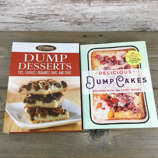 Two cookbooks on a wooden surface, one titled 'Dump Desserts' and the other 'Delicious Dump Cakes'.